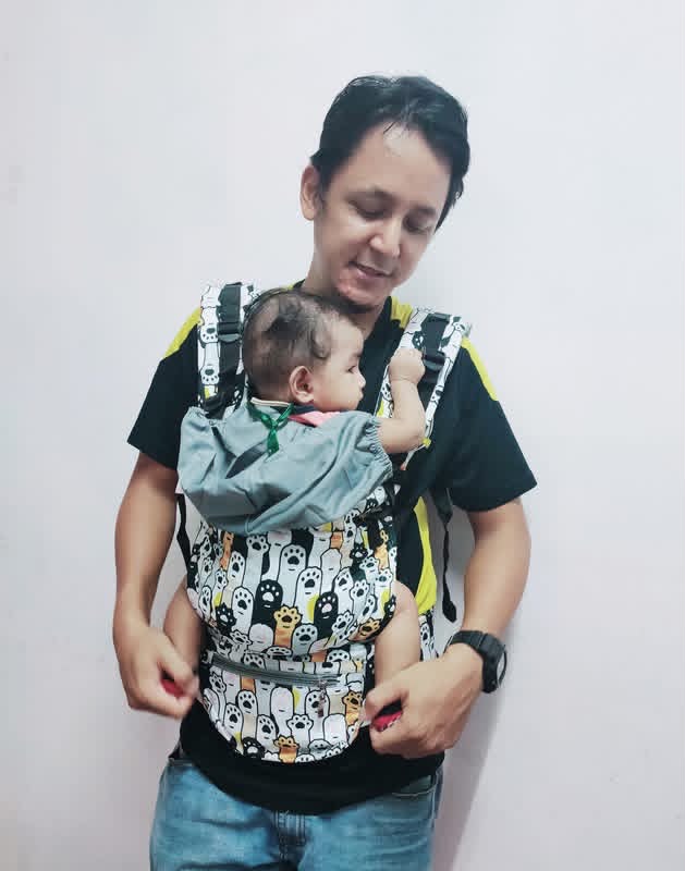 Ayah memakai baby carrier bersama bayinya