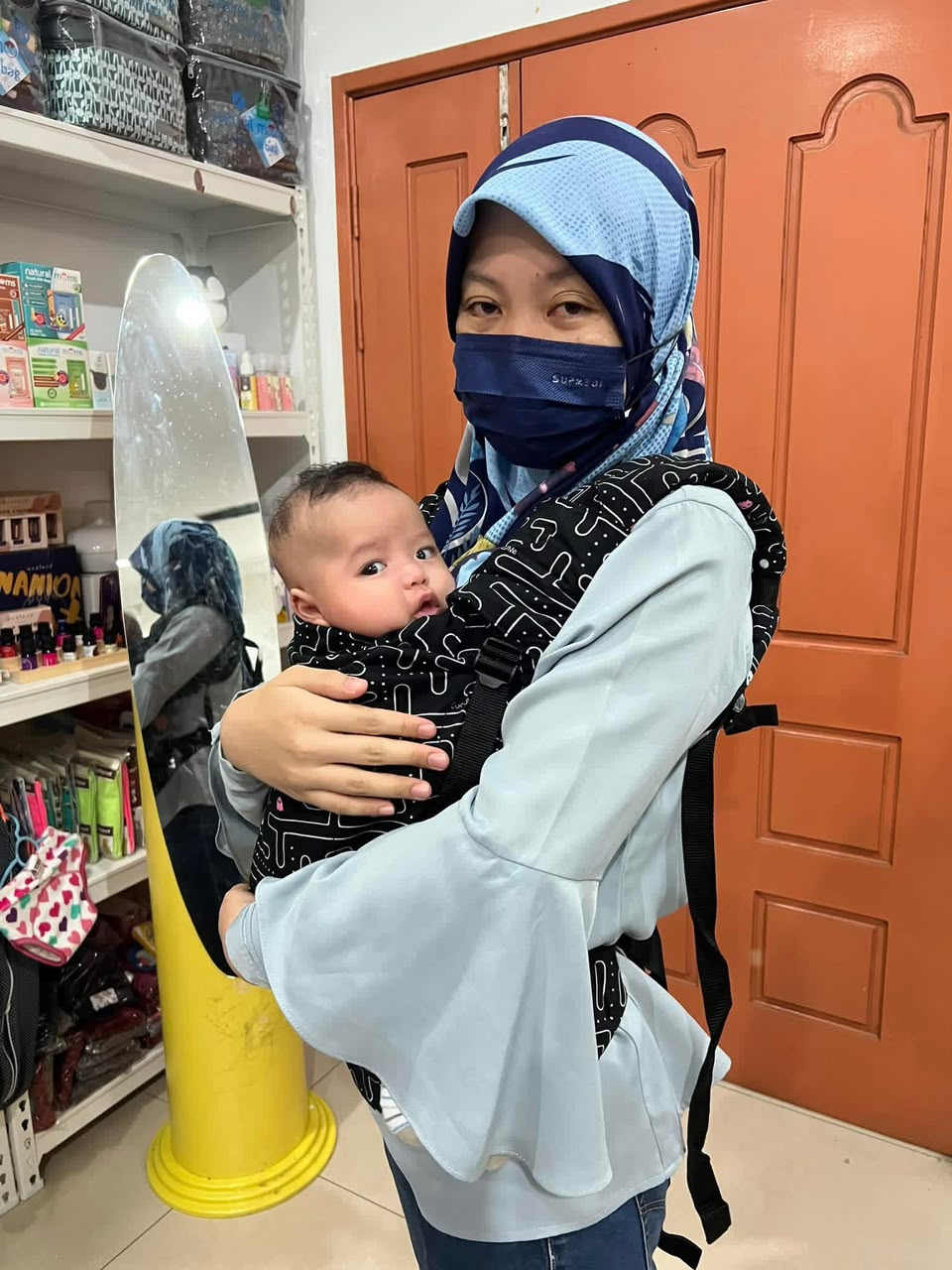 Ibu mendukung bayi dengan baby carrier selepas fitting