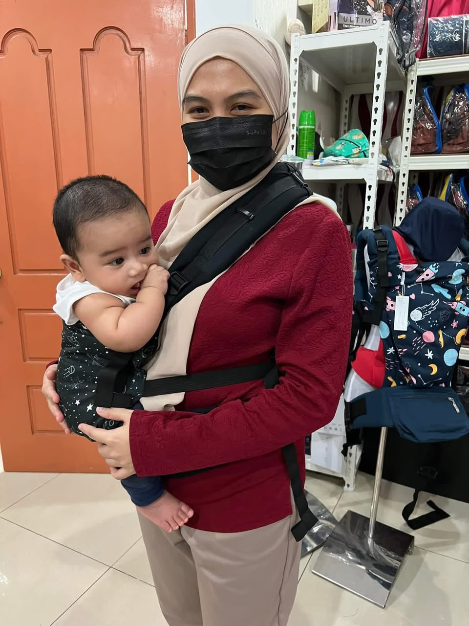 Ibu tersenyum selepas mencuba baby carrier bersama bayinya